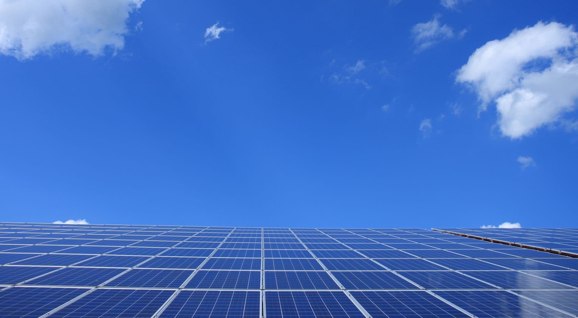 Solar panels rising into a bright blue sky